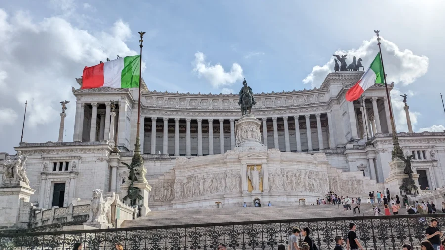 Rome Destination Guide: How to roam when in Rome 1 Victor Emmanuel II Monument with Italian flags and statue in this Rome Destination Guide
